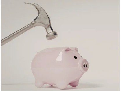 Hammer above a piggy bank.